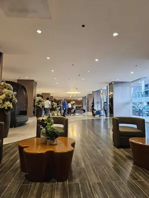 a lobby with a table and chairs in a building at Spacious 1BR beside MOA with Wifi, Netflix, Pool & Washer in Manila