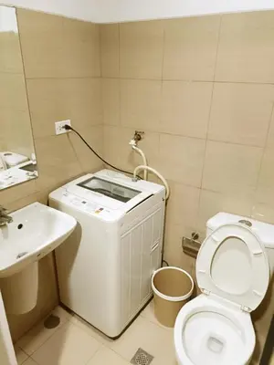 a small bathroom with a toilet and a sink at Spacious 1BR beside MOA with Wifi, Netflix, Pool & Washer in Manila
