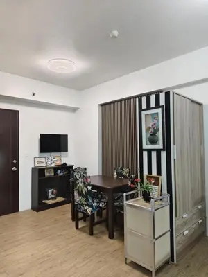 a living room with a table and a desk at Staycation Alabang by Larsen in Manila