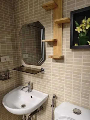 a bathroom with a sink and a mirror and a toilet at Staycation Alabang by Larsen in Manila