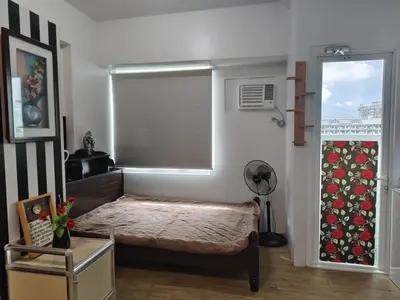 a small bedroom with a bed and a window at Staycation Alabang by Larsen in Manila