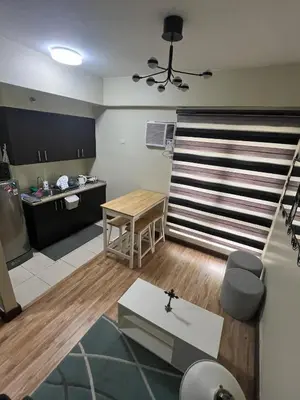 a living room with a table and a kitchen at Staycation Alabang by Larsen in Manila