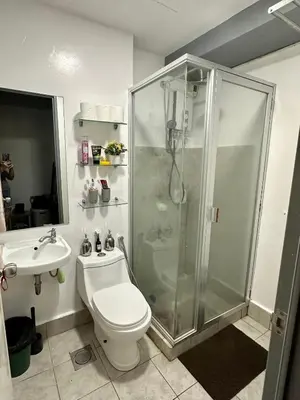 a bathroom with a shower and a toilet and a sink at Amaia skies cubao in Manila