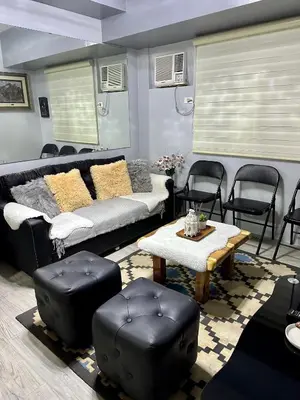 a living room with a couch and a table and chairs at Amaia skies cubao in Manila