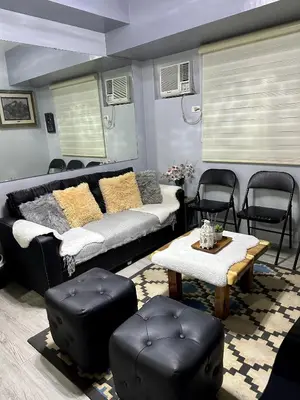 a living room with a couch and a table and chairs at Amaia skies cubao in Manila