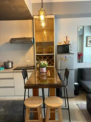 a kitchen with a table and stools in a room at Amaia skies cubao in Manila