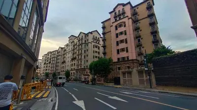 a city street with tall buildings and a van at Your Home at One Palm Tree Villas near NAIA T3 in Manila