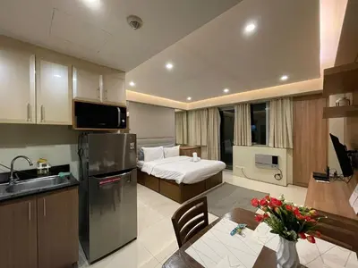 a room with a kitchen and a bedroom with a bed at Your Home at One Palm Tree Villas near NAIA T3 in Manila