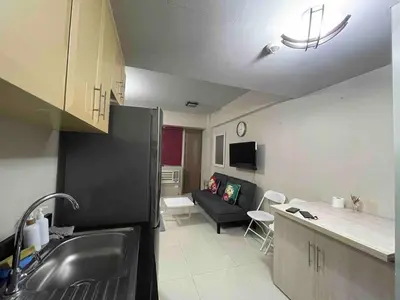a kitchen and living room with a black refrigerator at Your Home at One Palm Tree Villas near NAIA T3 in Manila