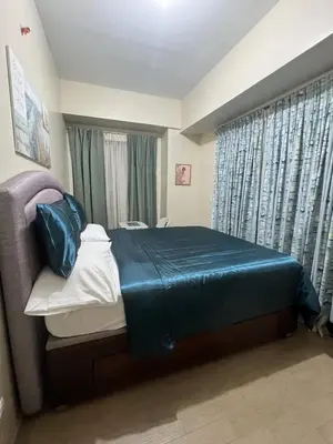 a bedroom with a bed with a blue blanket on it at Altitude Abode at Eighty One Across NAIA 3 in Metro Manila in Manila