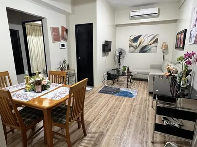a living room with a table and chairs and a couch at Altitude Abode at Eighty One Across NAIA 3 in Metro Manila in Manila