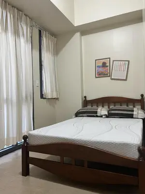 a bedroom with a bed in a room with a window at Altitude Abode at Eighty One Across NAIA 3 in Metro Manila in Manila