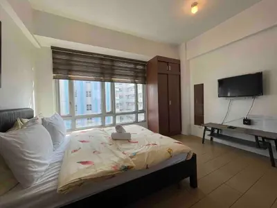 a bedroom with a bed and a large window at Tiny home near NAIA Terminal 3 in Manila