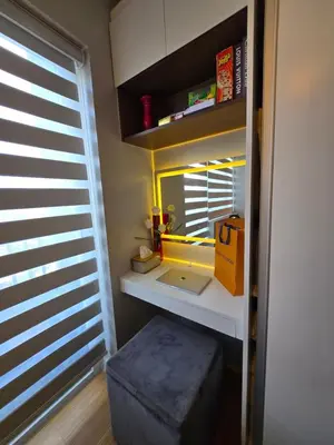 a room with a desk with a laptop and a window at The Snug Spot at Grace Residences Taguig in Manila