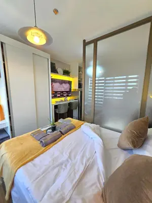 a bedroom with a bed with two towels on it at The Snug Spot at Grace Residences Taguig in Manila
