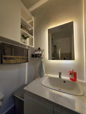 a bathroom with a sink and a mirror at The Snug Spot at Grace Residences Taguig in Manila