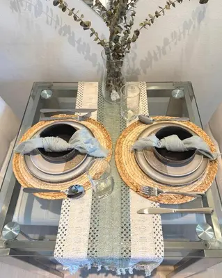a glass table with plates and a vase on it at Cozy Green 1 BR unit with Balcony Azure Bahamas South in Manila