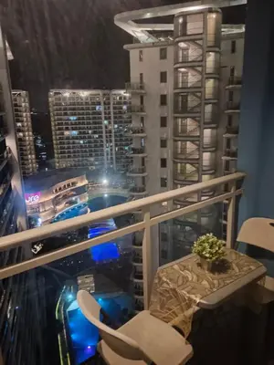 a balcony with a table and chairs and a city at 1BR Condotel in Azure Urban Resort Near NAIA #BH1 in Manila