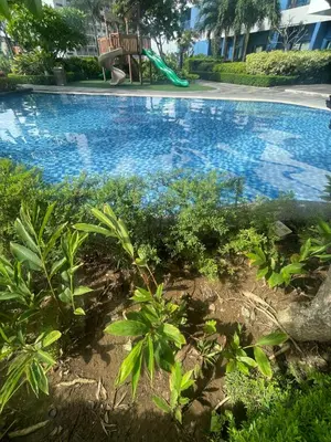 a swimming pool with a bench in a yard at Air Residences staycation2 in Manila