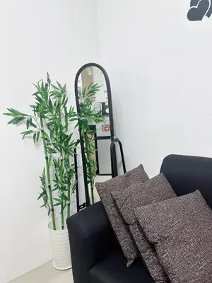 a mirror sitting next to a black chair with plants at Shore Stay in Manila