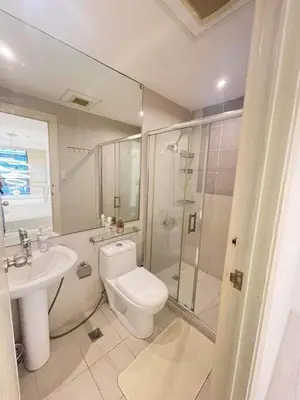 a bathroom with a toilet and a shower and a sink at Minimalist 1 Bedroom Loft Makati in Gramercy Residences in Manila