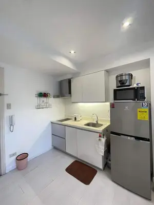 a small kitchen with a sink and a refrigerator at Minimalist 1 Bedroom Loft Makati in Gramercy Residences in Manila