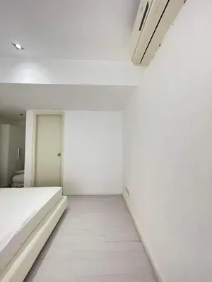 a white room with a bed and a white wall at Minimalist 1 Bedroom Loft Makati in Gramercy Residences in Manila