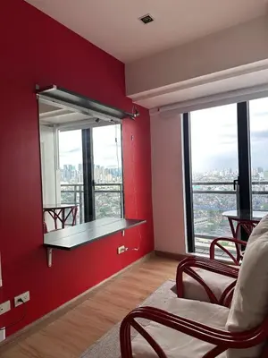 a room with a red wall with a shelf and windows at Stylish City View Flat Cozy with Netflix WIFI in The Knightsbridge Residences in Manila