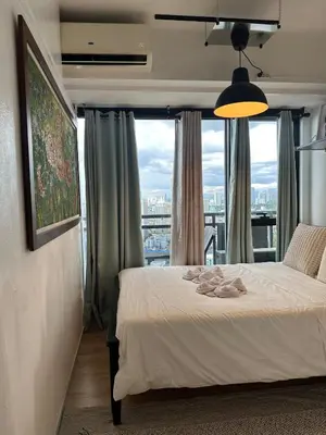 a bedroom with a bed and a large window at Stylish City View Flat Cozy with Netflix WIFI in The Knightsbridge Residences in Manila
