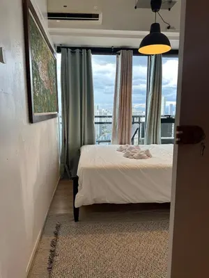 a bedroom with a bed and a window with a view at Stylish City View Flat Cozy with Netflix WIFI in The Knightsbridge Residences in Manila