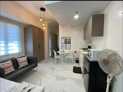 a kitchen and living room with a couch and a table at A peace crib Eastwood in Manila