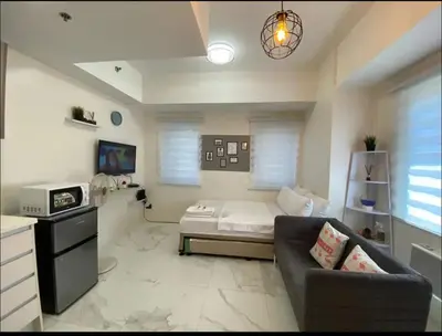 a living room with a couch and a bed at A peace crib Eastwood in Manila