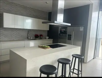 a kitchen with a counter with three stools in it at A peace crib Eastwood in Manila