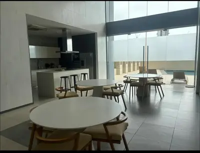a room with tables and chairs and a kitchen at A peace crib Eastwood in Manila