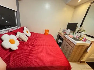 two stuffed animals are sitting on a red bed at Columbres Place in Manila
