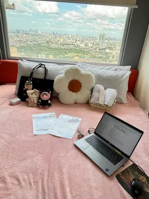 a laptop computer sitting on top of a bed with a window at Columbres Place in Manila
