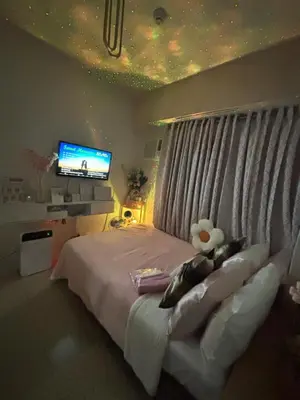 a bedroom with a bed with a television and a window at Columbres Place in Manila