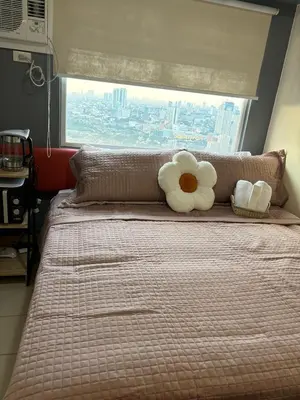 a bed with a white flower on top of it at Columbres Place in Manila