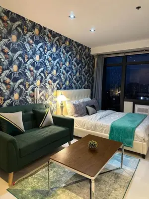 a living room with a bed and a couch at Modern Studio with Balcony in The Gramercy Residences in Manila