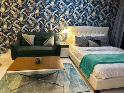 a living room with a bed and a couch at Modern Studio with Balcony in The Gramercy Residences in Manila