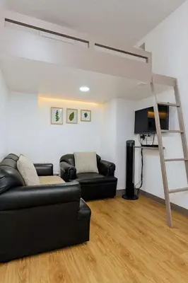 a living room with a couch and a loft bed at Close by the airports and tourist attractions in Manila
