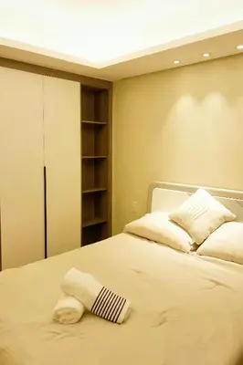 a bedroom with a white bed with a book shelf at Happy Holiday in Manila