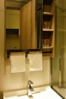 a bathroom with a sink and a mirror and towels at Happy Holiday in Manila