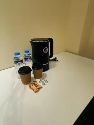 a coffee maker and two bottles of water on a counter at Happy Holiday in Manila