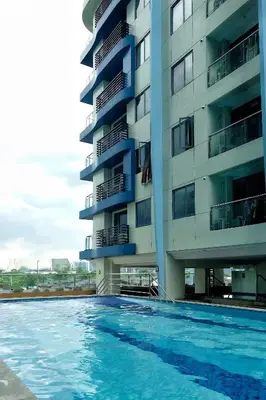 a swimming pool in front of a building at Happy Holiday in Manila