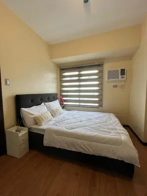 a bedroom with a large bed with a window at Cozy, aesthetic Pet friendly 1br Condo with balcony in Pasay with Manila Bay View Near MOA & Okada WFH ready Free Pool Acces Gym and Sauna in Manila
