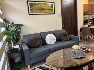 a living room with a blue couch and a table at Cozy, aesthetic Pet friendly 1br Condo with balcony in Pasay with Manila Bay View Near MOA & Okada WFH ready Free Pool Acces Gym and Sauna in Manila