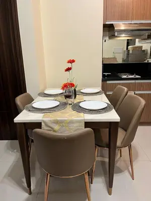 a dining room table with chairs and plates and a kitchen at Cozy, aesthetic Pet friendly 1br Condo with balcony in Pasay with Manila Bay View Near MOA & Okada WFH ready Free Pool Acces Gym and Sauna in Manila