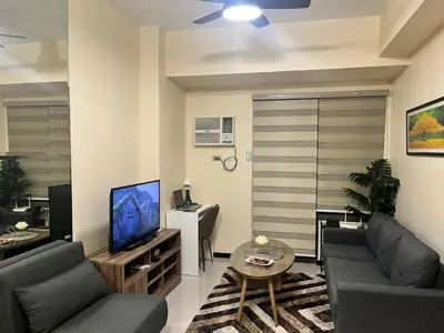 a living room with a couch and a tv at Cozy, aesthetic Pet friendly 1br Condo with balcony in Pasay with Manila Bay View Near MOA & Okada WFH ready Free Pool Acces Gym and Sauna in Manila