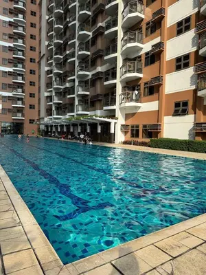 a large swimming pool in front of a building at Cozy, aesthetic Pet friendly 1br Condo with balcony in Pasay with Manila Bay View Near MOA & Okada WFH ready Free Pool Acces Gym and Sauna in Manila